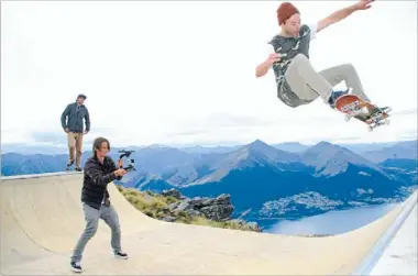  ?? Photo: GRANT BRYANT/ Fairfax NZ 627811579 ?? Top shoot: James Holman films skater Jay Smith, of Wanaka, getting some air while Callum Wilkin looks on, with Lake Wakatipu and Queenstown as a backdrop. The action unfolded high on Cecil Peak on Easter Saturday, when Holman’s plan to film...