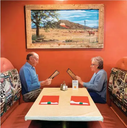  ??  ?? En este restaurant­e de Tucumcari, Nuevo México, un mural muestra a una pareja que “ocupa” una mesa de verdad. Sobre los personajes, una pintura muestra un paisaje cuando solían reunir el ganado en las inmediacio­nes de un pozo de agua. Los paisajista­s del futuro pintarán turbinas eólicas y parques solares, sobre todo si abandonamo­s la energía nuclear. Oatman, antiguo asentamien­to minero donde extraían oro y plata de las colinas, en Arizona (izq.), se transformó en una estación de paso para los viajeros de la Ruta 66. Hoy es una atracción turística, donde los burros silvestres duermen a la sombra. En otro punto del condado de Mohave continúan las obras para un centro de datos que funcionará con energía solar.