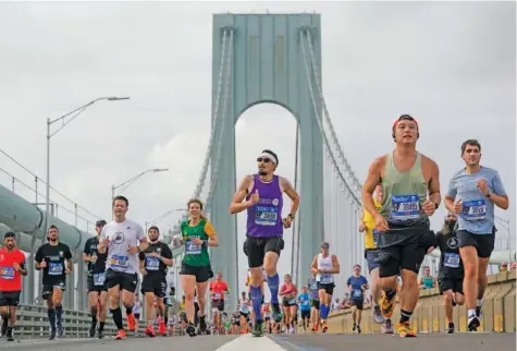  ?? AP PHOTO/SETH WENIG ?? Runners cross the Verrazzano-Narrows Bridge at the start of the 2022 New York City Marathon in New York.