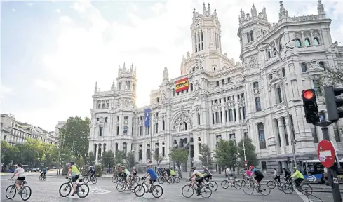  ?? AFP ?? Cyclists ride their bikes in front of Madrid’s city hall at Cibeles square in Madrid on Saturday.