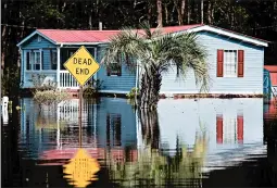  ?? SEAN RAYFORD/GETTY ?? A home is surrounded by floodwater­s caused by Hurricane Florence in Longs, S.C. A research firm estimates the storm caused around $44 billion in damage and lost output.