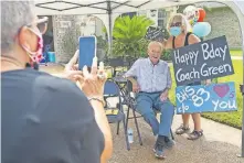  ?? [MICHAEL MILLER/BRYAN EAGLE] ?? Merrill Green's daughter, Sylvia Franze, takes a picture of Green with Kathy Childers during a drive-by 90th birthday party for Green in Bryan, Texas, last Saturday.