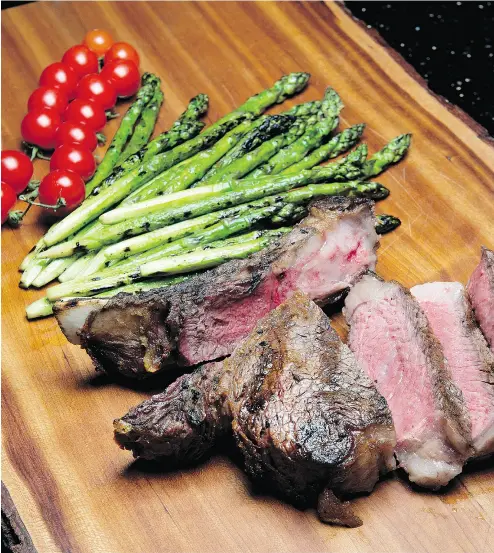  ?? PETER J. THOMPSON / NATIONAL POST ?? Ray Rupert’s grilled bone-in rib steak with grilled asparagus. Ray’s advice for Father’s Day is to forget gifts, forget anything fancy and just teach your father (or father figure) how to properly grill a great big fat rib steak.