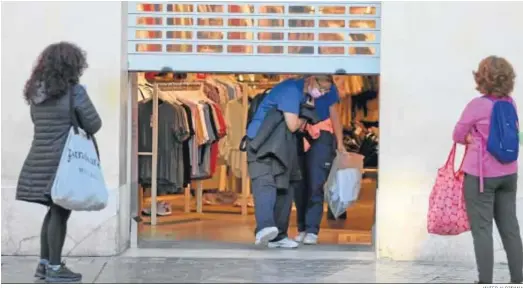  ?? JAVIER ALBIÑANA ?? Una de las tiendas de ropa del centro de Málaga echa la persiana tras terminar su actividad a las 18:00.