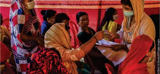  ??  ?? HARD-HIT: An official registers the details of sex workers during a vaccinatio­n drive held in Daulatdia last Wednesday (18)