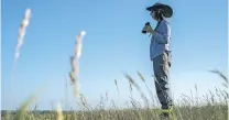  ?? JOSHUA A. BICKEL/THE ASSOCIATED PRESS ?? Sharon Kennedy of Lincoln, Neb., looks for birds in June while on a grassland birds tour in Denton, Neb. North America’s grassland birds are deeply in trouble 50 years after adoption of the Endangered Species Act, with numbers plunging.