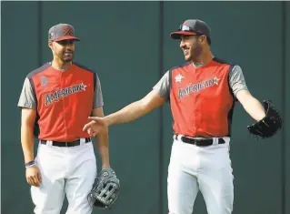  ?? Photos by Gregory Shamus / Getty Images ?? American League AllStars J.D. Martinez (left) of the Red Sox and Justin Verlander of the Astros talk during a workout at Progressiv­e Field in Cleveland.