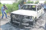  ??  ?? Photojourn­alists capture the remains of a car torched by unknown people at Kotli village in Sirsa on Monday. Barring sporadic incidents of arson, the day remained largely peaceful. PTI