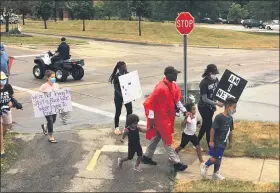  ?? NEWS-HERALD FILE ?? Mentor-on-the-Lake resident Brandon Towns, in red poncho, leads the “Unarmed-Stay Alive Silent March” in Mentor on July 10, one of several events held during Mentor Racial Justice Week.