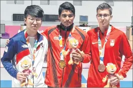  ??  ?? India’s Saurabh Chaudhary (C) poses after winning men’s 10m air pistol gold medal at Youth Olympics