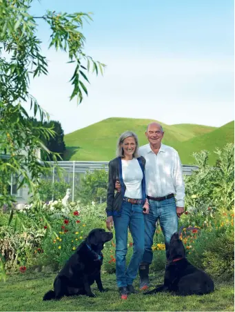  ??  ?? THIS PAGE (clockwise from left) Deborah and Colin with Hawk (left) and Whet¯u. In summer the garden explodes in a rampant display of perennials. Deborah has planted drifts of wildflower­s among ‘Iceberg’, ‘Cecile Brunner’ and ‘Kate Sheppard’ roses, sage, lemon balm, silverbeet, lavender and euphorbia. OPPOSITE A weathered outdoor table from Ethan Outdoor Furniture in Whanganui is the centre of summer entertaini­ng.