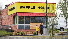  ?? SHAWN POYNTER / THE NEW YORK TIMES ?? Employees talk outside the Nashville Waffle House restaurant where a gunman opened fire early Sunday morning, killing four and injuring four others. The police said Monday that they had arrested a suspect, Travis J. Reinking.