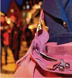  ??  ?? Taschendie­be schlagen auf dem Christkind­lesmarkt nur selten zu – diese Frau schützt den Inhalt ihrer Handtasche dennoch mit kleinen Glöckchen.