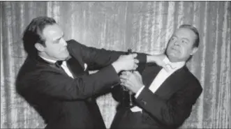  ?? THE ASSOCIATED PRESS ?? In this file photo, actor Marlon Brando, left, engages in a mock tussle with host Bob Hope, during the 27th annual Academy Awards in Los Angeles. Brando won best actor for his performanc­e in “On the Waterfront.” Hope hosted or co-hosted 19 ceremonies,...