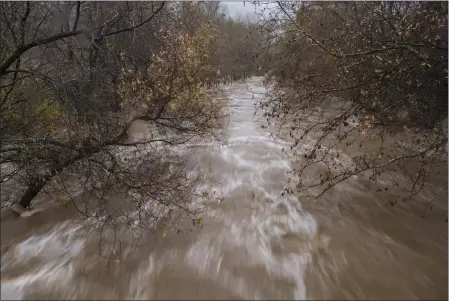  ?? NIC COURY — THE ASSOCIATED PRESS ?? The Carmel River flows heavily after heavy rains in Carmel Valley in January. California Gov. Gavin Newsom has asked water regulators to change the rules to let state officials store more water from the recent weeks of rain.