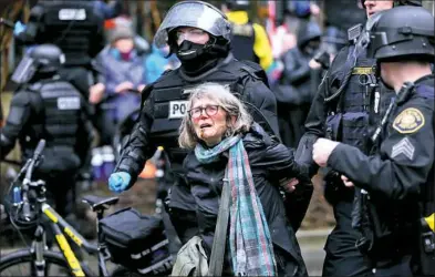  ?? Dave Killen/The Oregonian via AP ?? A woman is detained during a protest Monday in Portland, Ore. Thousands of demonstrat­ors turned out across the U.S. to challenge President Donald Trump in a Presidents Day protest dubbed Not My President's Day.