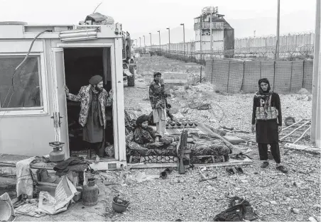  ?? David Guttenfeld­er / New York Times ?? Taliban fighters on Dec. 5 guard the abandoned prison at Bagram Air Base, a former U.S. military base. The Afghan prison once held thousands of Taliban and al-Qaida members who were set free in August.