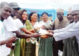  ?? Photo: Latifat Opoola ?? Some of the corp members presenting improved seeds to farmers in Abuja’s Dei Dei community at the sensitisat­ion session.