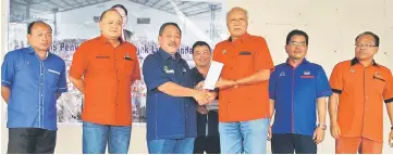  ??  ?? Sagah (third left) presents an MRP cheque to a recipient. Also seen are (from right) Tuah, Genot, Lim and Ranum.
