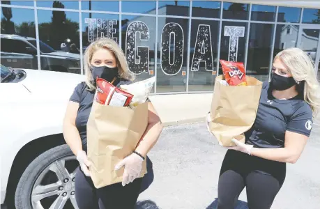  ?? PHOTOS: NICK BRANCACCIO ?? G.O.A.T. Tap and Eatery managers Zeina Youssef, left, and Susannah Obeid carry customers’ grocery orders at the restaurant’s Malden Road location. A brainstorm led the eatery to realize customers could be offered groceries as well as prepared items during the pandemic.