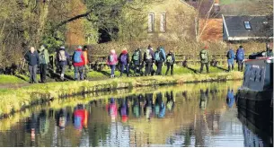  ??  ?? The ramblers are reflected in the Macclesfie­ld Canal on their walk through Bollington