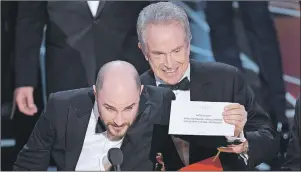  ?? AP PHOTO ?? Jordan Horowitz, left, producer of “La La Land,” shows the envelope revealing “Moonlight” as the true winner of best picture at the Oscars on Sunday at the Dolby Theatre in Los Angeles. Presenter Warren Beatty looks on.