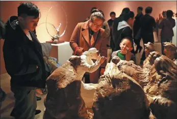  ?? PHOTOS PROVIDED AND BY JIANG DONG / CHINA DAILY ?? From left: Sculptures which reflect Chinese artists’ feelings about ethnic diversity are on show at the National Art Museum of China in Beijing. A work that depicts musicians of the Jing ethnic group by Huang Bingyi is on display.