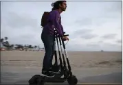  ?? MARIO TAMA – GETTY IMAGES ?? A man rides a Bird shared dockless electric scooter while transporti­ng three other scooters along Venice Beach in Los Angeles in 2018. Emergency rooms are seeing a lot of head injuries, many with vision-threatenin­g damage to the eyes, a small study suggests.