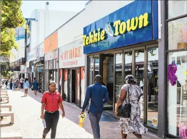  ?? PHOTO: BLOOMBERG ?? Pedestrian­s pass the front of a Tekkie Town shoe store, operated by Steinhoff Africa Retail (STAR), in Stellenbos­ch. Tekkie Town is an important part of STAR, operating more than 380 stores, and providing employment to more than 3 000 people.