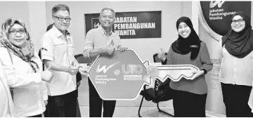  ??  ?? Othman (third left) receives a replica key to symbolise the launching of the Women Developmen­t Department’s office at UTC Kuching yesterday. — Bernama photo