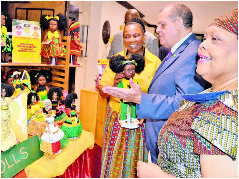  ?? CONTRIBUTE­D ?? In this May 2018 photo, president of Island Dolls Plus Collection, Beverley Robotham-Reynolds (left), shows Minister of Industry, Commerce, Agricultur­e and Fisheries Audley Shaw the company’s line of dolls, during a tour of exhibits, at the 11th Annual Jamaica Business Developmen­t Corporatio­n’s (JBDC) Small Business Expo and Conference, held at The Jamaica Pegasus hotel, New Kingston. At right is Chief Executive Officer of JBDC Valerie Veira.