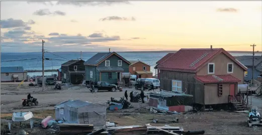  ?? CP PHOTO ?? Residents go about their business as the sun sets on the town of Gjoa Haven, Nunavut.