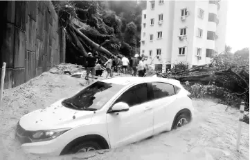  ??  ?? Cars are buried in mud at Pangsapuri Kayangan Puri Mutiara, Tanjung Bungah. — Bernama photo