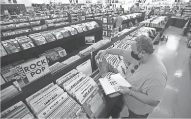  ??  ?? David Derry looks through the records at Zia Records in Phoenix on Oct. 29.