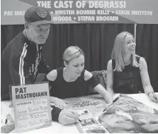  ??  ?? Stefan Brogren, left, Stacie Mistysyn and Kirsten Bourne sign a poster.