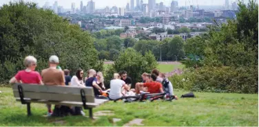  ?? Reuters ?? ↑ People relax on Parliament Hill during warm weather in London on Sunday.