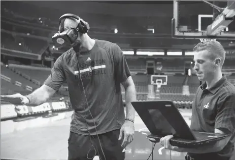  ?? Photo by Katherine Frey / The Washington Post ?? Washington Wizards center Marcin Gortat (left) with VR glasses in November 2015. The Washington Wizards, Capitals and Mystics are using virtual reality as a training tool.