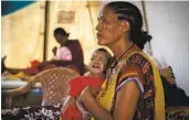  ?? BEN CURTIS ?? A Tigray woman holds her malnourish­ed child in the treatment tent of a medical clinic in Ethiopia.