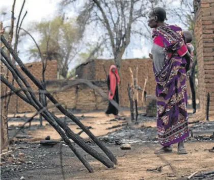  ?? REUTERS ?? Una mujer observa los restos de una casa tras los enfrentami­entos entre nómadas y residentes en Deleij.
