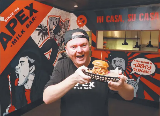  ?? Picture: JUSTIN BRIERTY ?? MORE TO COME: Apex Milk Bar’s head chef Eddie Richardson shows off the outlet’s Miss Piggy Burger.