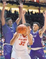  ?? JIM THOMPSON/JOURNAL ?? UNM’s Tim Williams (32) is guarded by Abilene Christian’s Jalone Friday, left, and Diamante Langston during Wednesday night’s game.