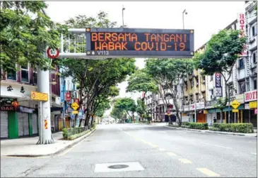  ?? AFP ?? A giant LED board displaying a sign that reads, ‘Together we handle the Covid-19 outbreak’ is seen during the control of movement of people in Kuala Lumpur. Malaysia will likely see an extension of its ongoing movement curbs.