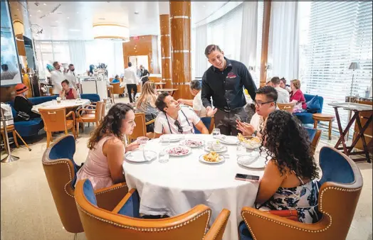  ?? PHOTOS BY STEVE MARCUS ?? Lip Smacking Foodie Tours founder Donald Contursi checks on a table at Cipriani, an Italian restaurant at the Wynn Las Vegas, during a tour last Saturday. The afternoon tour included four restaurant­s at the Venetian and Wynn.