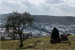  ?? (Getty) ?? A displaced Syrian looks down on the newly built camp at Atmeh, near Idlib