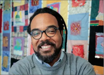  ?? Arkansas Democrat-Gazette/JOHN SYKES JR. ?? Ryan Davis poses in front of a “social justice quilt” at Children Internatio­nal, the organizati­on he directs. Children Internatio­nal is just one of the organizati­ons that benefits from AACF’s research and advocacy.