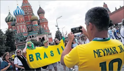  ??  ?? ENTUSIASMO CON LA CANARINHA. Varios aficionado­s brasileños posan delante de la catedral de San Basilio en la Plaza Roja de Moscú.