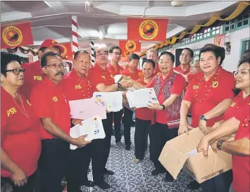  ??  ?? (From fourth left) Entri, Entulu, Wong and others show some of the new PSB membership applicatio­n forms received from residents of 78 longhouses in Baram.