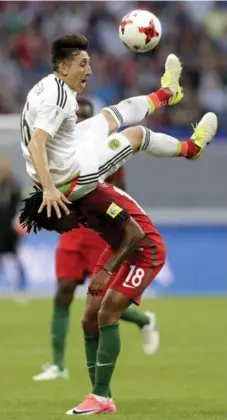  ?? THANASSIS STAVRAKIS/THE ASSOCIATED PRESS ?? Mexico midfielder Hector Herrera goes over the top of Portugal’s Gelson Martins during Confederat­ions Cup play in Kazan, Russia on Sunday. The teams played to a 2-2 draw.