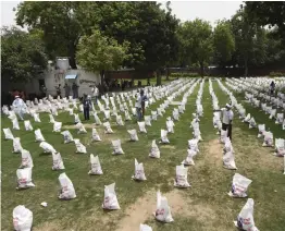  ?? — PTI ?? Youth Congress members arrange sacks filled with food items to distribute among needy people on Congress leader Rahul Gandhi's 50th birthday in New Delhi on Friday.