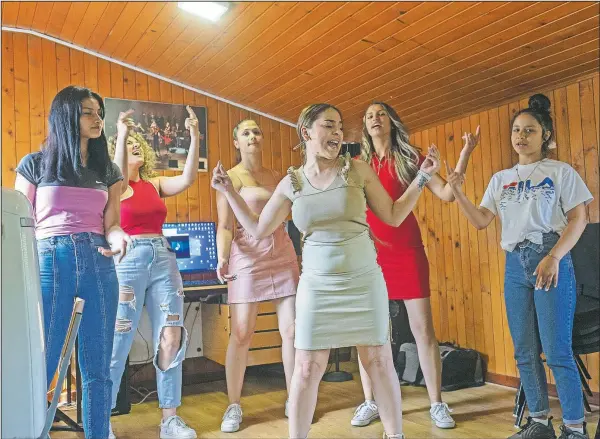  ?? (AP/Marko Drobnjakov­ic) ?? Zlata Ristic (center), 27, Elma Dalipi (left), 14, Silvia Sinani (second left), 24, Dijana Ferhatovic (third), 18, Zivka Ferhatovic (second right), 20, and Selma Dalipi, 14, all members of the Pretty Loud band, practice at a music studio in Belgrade, Serbia. The female Roma, or Gypsy, band in Serbia is using music to preach women’s empowermen­t within their community. Formed in 2014, “Pretty Loud” symbolical­ly seeks to give a louder voice to Roma girls, encourage education and steer them away from the widespread custom of early marriage.